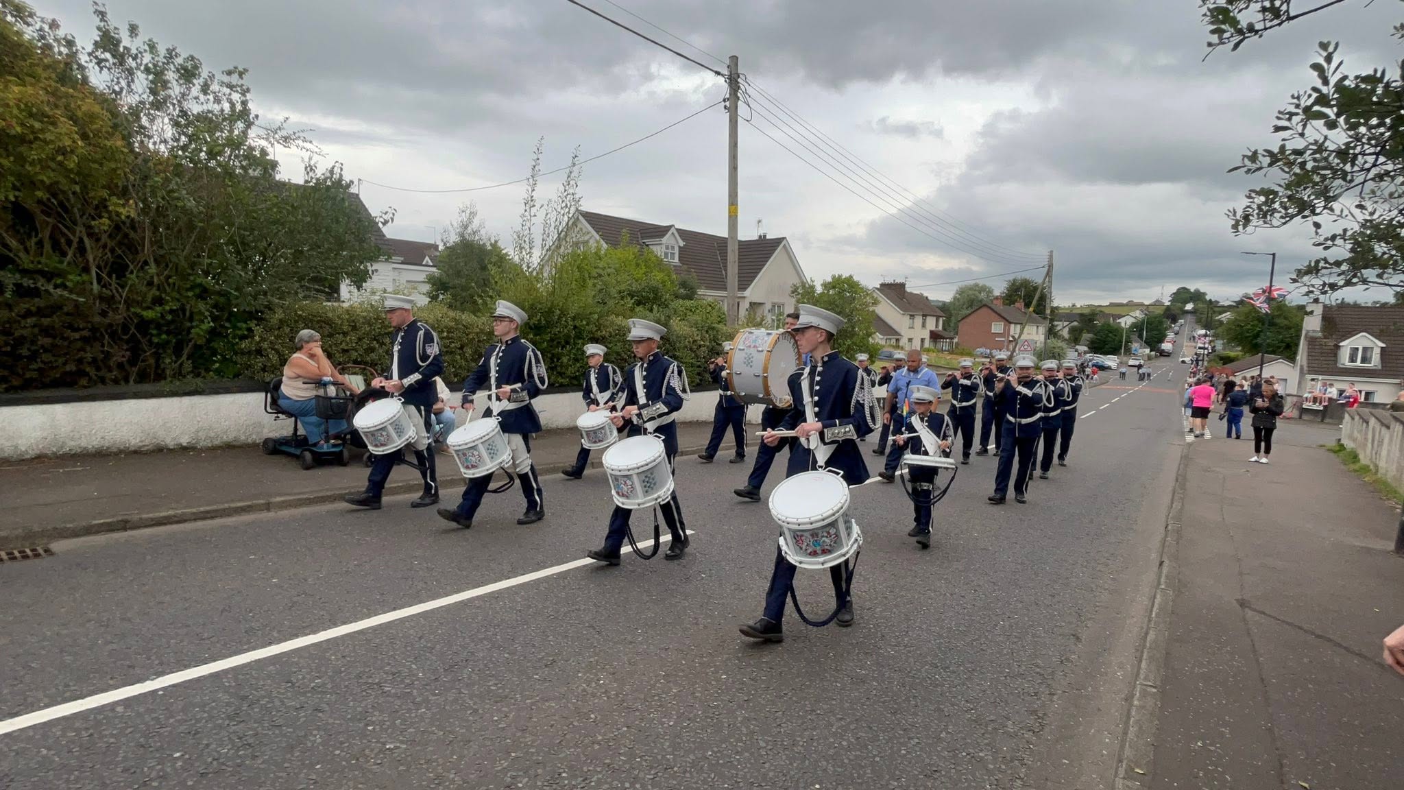 Finaghy True Blues Flute Band marching with flutes and drums in navy uniforms