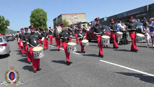 Shankill Star Flute Band marching with drummers in black uniforms and red trousers